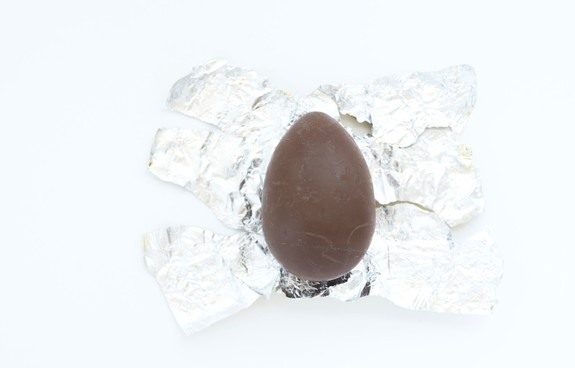 rozpakowane czekoladowe jajko niespodzianka leżące na papierku