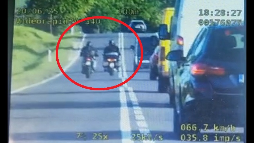 Stop klatka z wideorejestratora na której widać dwóch motocyklistów łamiących przepisy ruchu drogowego.