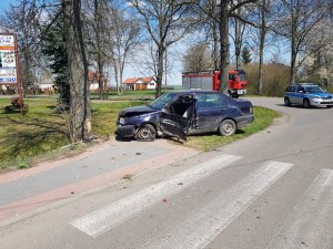 miejsce zdarzenia drogowego- rozbity pojazd osobowy obok stoi radiowóz i pojazd straży pożarnej