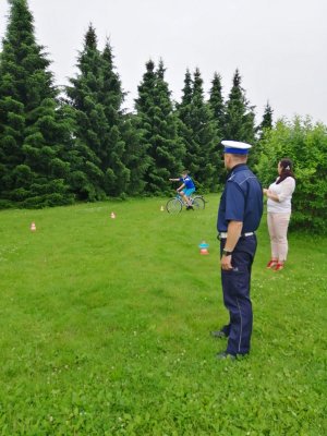 policjant przeprowadzający egzamin z umiejętności jazdy rowerem