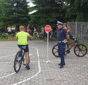 policjant umundurowany oraz uczeń na rowerze podczas egzaminu na karte rowerową
