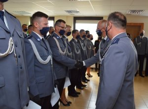 komendant inspektor Artur Deryło i I Zastępca nadkomisarz Bogdan Kulas wręczają akty mianowania policjantom