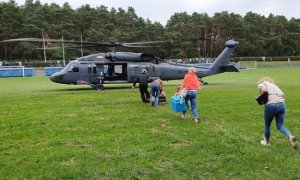 policyjny śmigłowiec i wsiadające do niego osoby