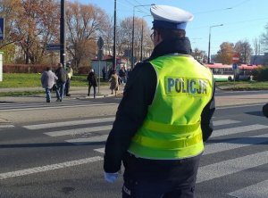 policjant ruchu drogowego nadzoruje przejście dla pieszych