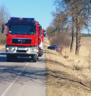 dwa zastępy straży pożarnej i samochód osobowy w rowie