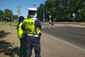 policjant i policjantka obserwują przejście dla pieszych