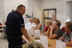 policjant na spotkaniu profilaktycznym z seniorkami