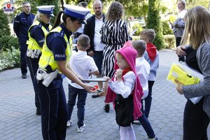 policjanci rozdają dzieciom odblaski