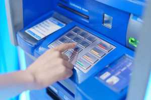 ręka wpisująca pin w bankomacie