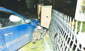 uszkodzony pojazd i ogrodzenie