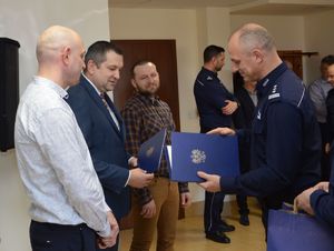 Komendant wręcza listy gratulacyjne emerytom