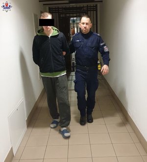 policjant prowadzi osobę zatzrymaną