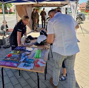 policjantka udziela informacji mężczyźnie z dzieckiem