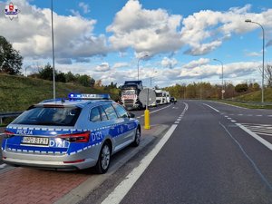 radiowóz w oddali protestujące ciężarówki