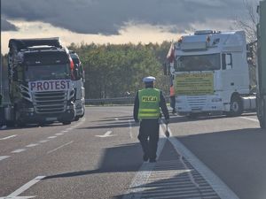 policjant pomiędzy ciężarówkami