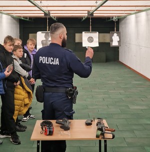 policjant z uczniami na strzelnicy