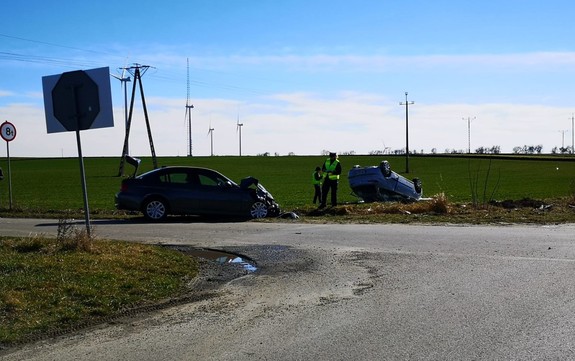 wypadek dwóch samochodów, samochód Seat leży na dachu, policjanci wykonują czynności na miejscu zdarzenia