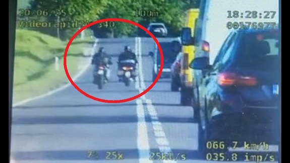 Stop klatka z wideorejestratora na której widać dwóch motocyklistów łamiących przepisy ruchu drogowego.