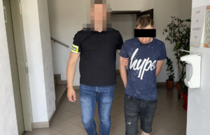 policjant prowadzi zatrzymanego