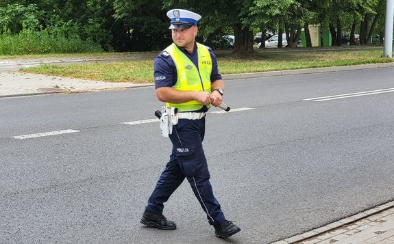 policjant na drodze z urządzeniem do pomiaru trzeźwości