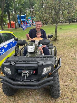 policjant na quadzie z dzieckiem