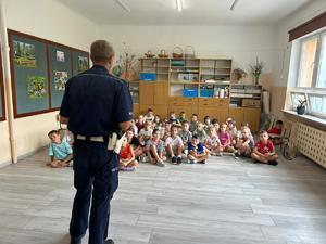 policjant przeprowadza pogadankę z dziećmi w szkole