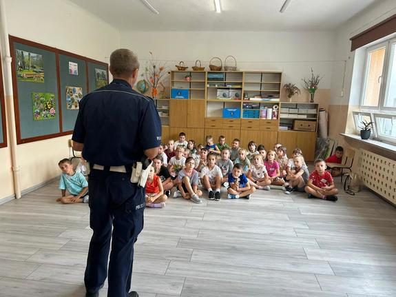 policjant przeprowadza pogadankę z dziećmi w szkole