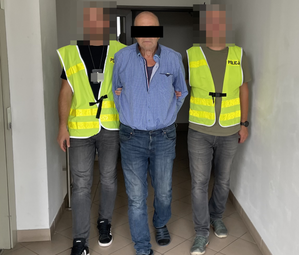 policjanci prowadzą zatrzymanego