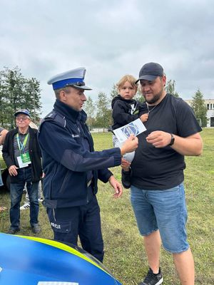 policjant wręcza ulotkę mężczyźnie