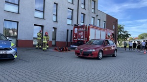 samochód przeznaczony do pokazu  w tle wóz strażacki i radiowóz policyjny