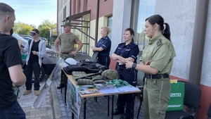 funkcjonariusze starzy granicznej i policji przy stoisku ze sprzętem służbowym