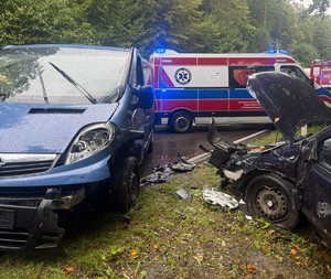 pojazdy po zderzeniu, opel Astra i Opel Vivaro, w tle karetka pogotowia