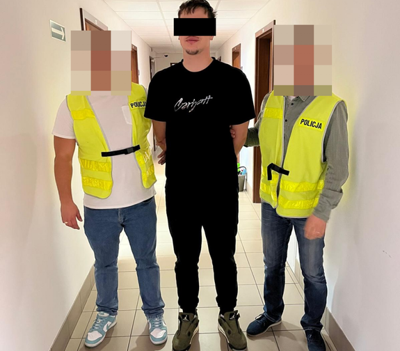policjanci prowadzą zatrzymanego