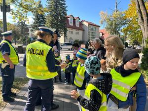 policjanci wręczają odblaski przedszkolakom