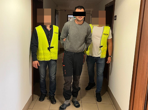 policjanci prowadzą zatrzymanego
