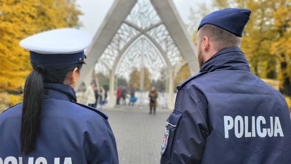 policjanci przed bramą cmentarza