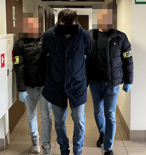 policjanci prowadzą zatrzymanego