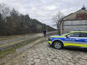 funkcjonariusze policji patrolują i sprawdzają teren linii kolejowej