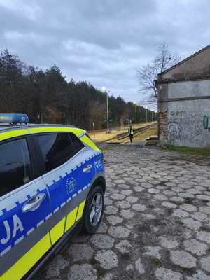 funkcjonariusze policji patrolują i sprawdzają teren linii kolejowej