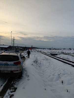 funkcjonariusze policji patrolują i sprawdzają teren linii kolejowej