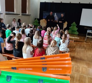 policjanci na spotkaniu z dziećmi, na pierwszym planie opaski odblaskowe