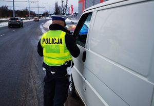 policjant przy pojeździe podczas kontroli drogowej