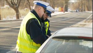 policjant przy pojeździe podczas kontroli drogowej