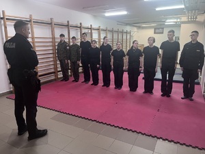 policjanci prowadzą zajęcia z uczniami w szkole z technik i taktyk interwencji