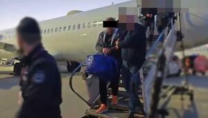 policjanci wychodzą z samolotu z osobą zatrzymaną