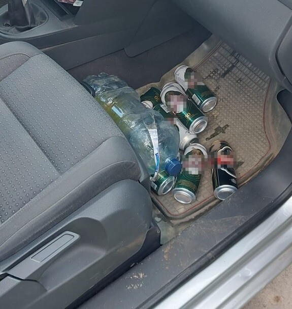 puszki po piwie na podłodze pojazdu