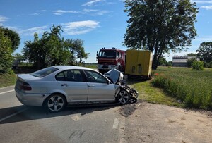uszkodzone pojazdy na miejscu zdarzenia, w tle wóz strażacki