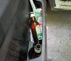 butelki alkoholu w przednich drzwiach pojazdu od strony kierowcy