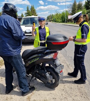 dwie policjantki i kierujący jednośladem. Policjantki sprawdzają trzeźwość cyklisty