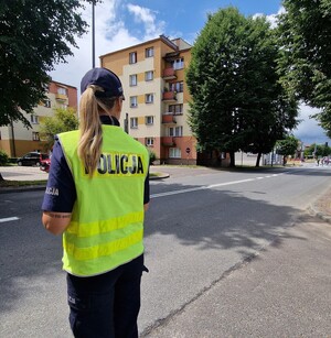 policjantka odwrócona placami obserwuje ruch na ulicy